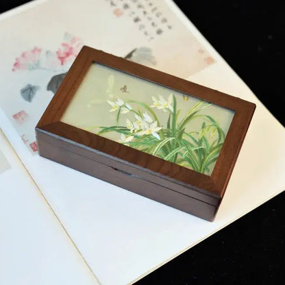 Wooden jewelry box with floral design on a textured surface