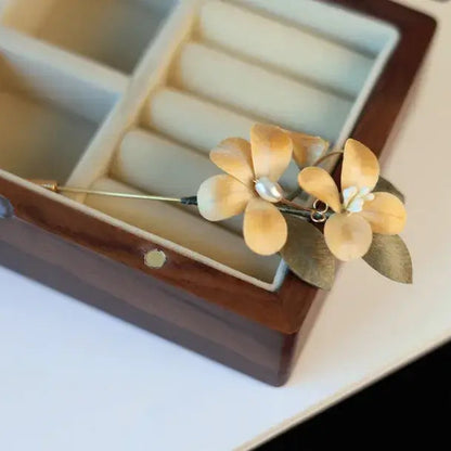 Gold flower-shaped earring in a jewelry box