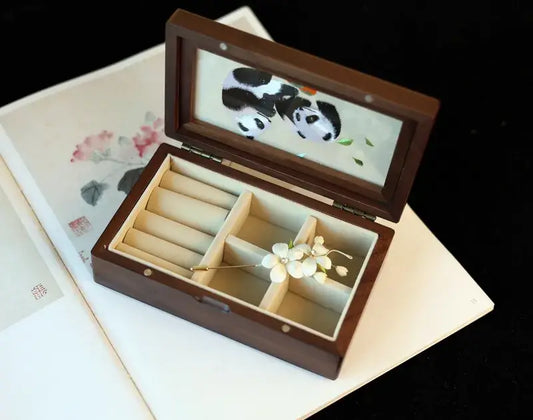 Wooden jewelry box with panda design on a black background