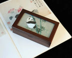 Wooden box with a panda illustration on a textured surface