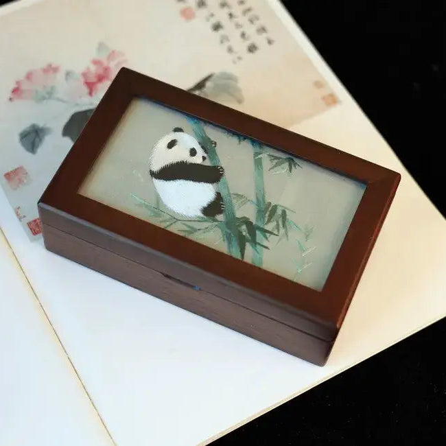 Wooden box with a panda illustration on a textured surface