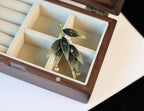 Green leaf-shaped earrings in a jewelry box