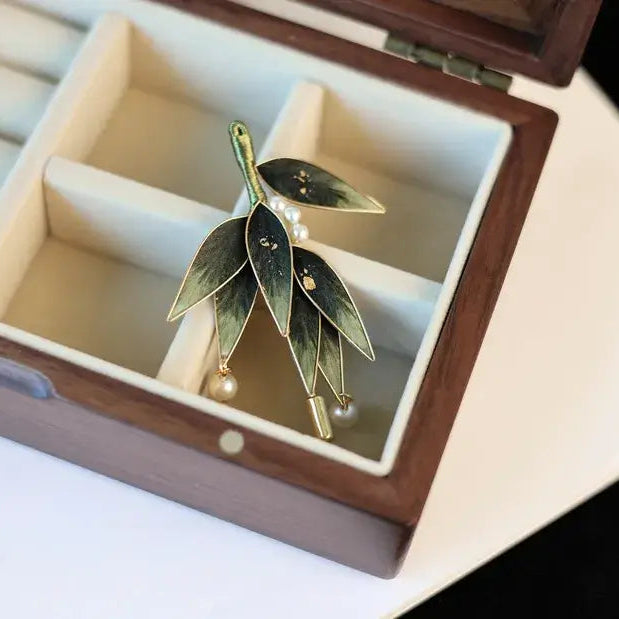 Green leaf-shaped earrings in a jewelry box
