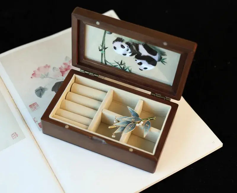 Jewelry box with a panda design on the lid, containing jewelry items.
