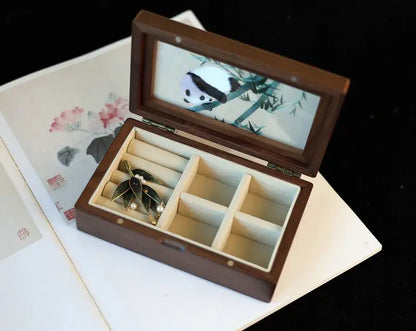 Wooden jewelry box with a lid featuring an embroidered design on a floral background.