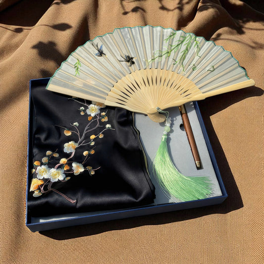 Decorative fan with floral design on a brown fabric background
