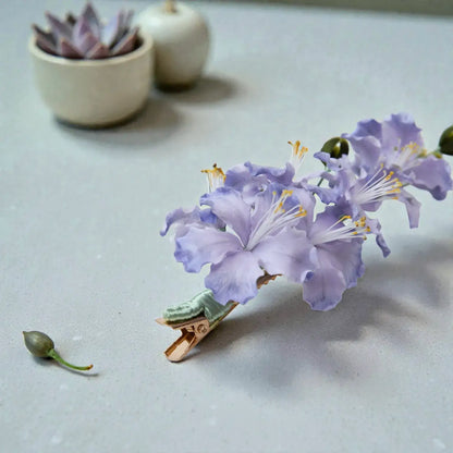 Purple flower on a clothespin with a light gray background