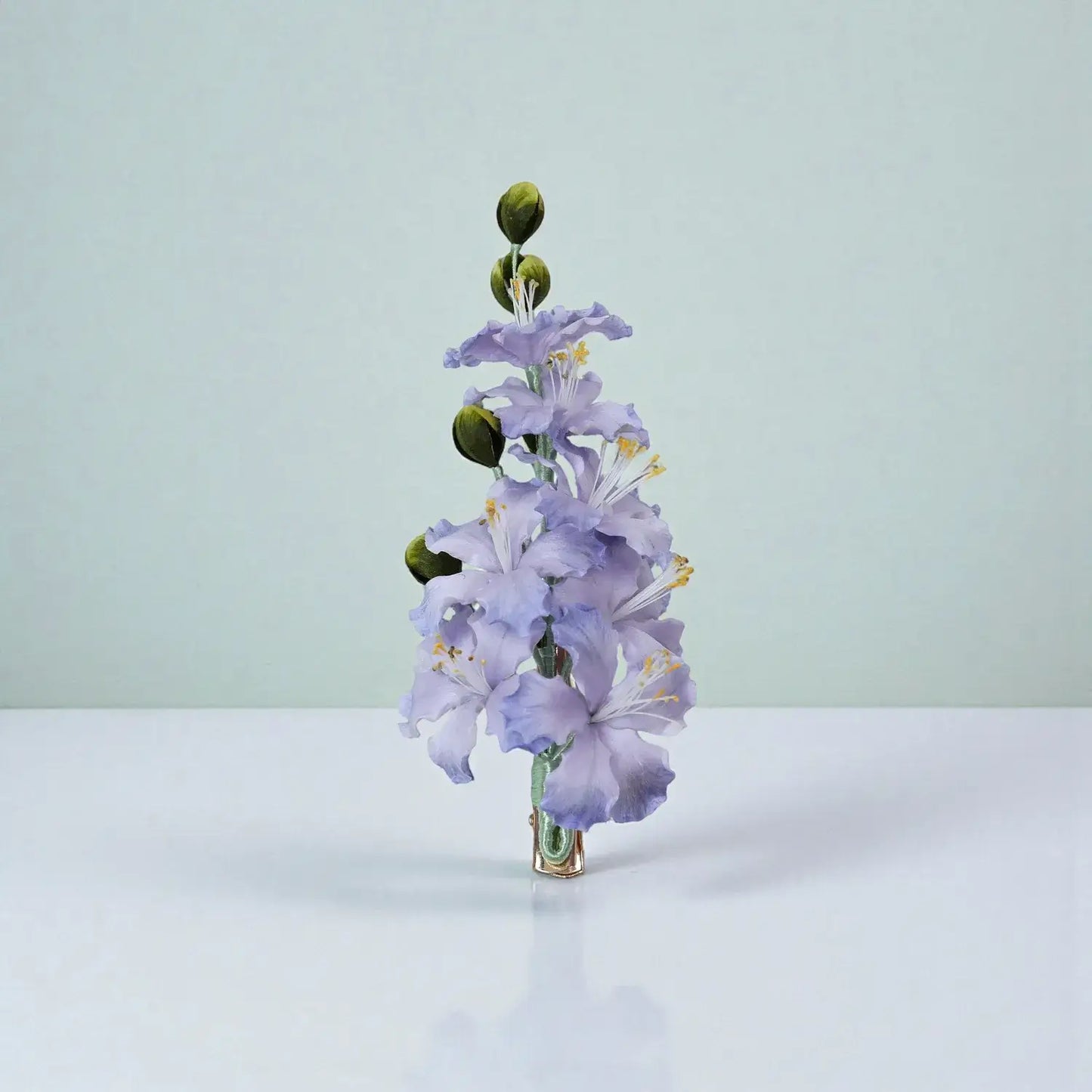 Purple flower arrangement on a white surface with a light green background