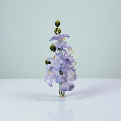 Purple flower arrangement on a white surface with a light green background