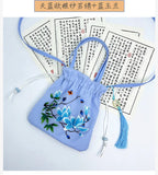 Blue embroidered bag with floral design on a white background