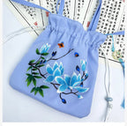 Light blue drawstring bag with floral embroidery on a white background