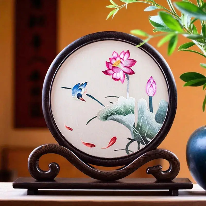 Decorative piece with lotus flower design on a wooden stand against a blurred background