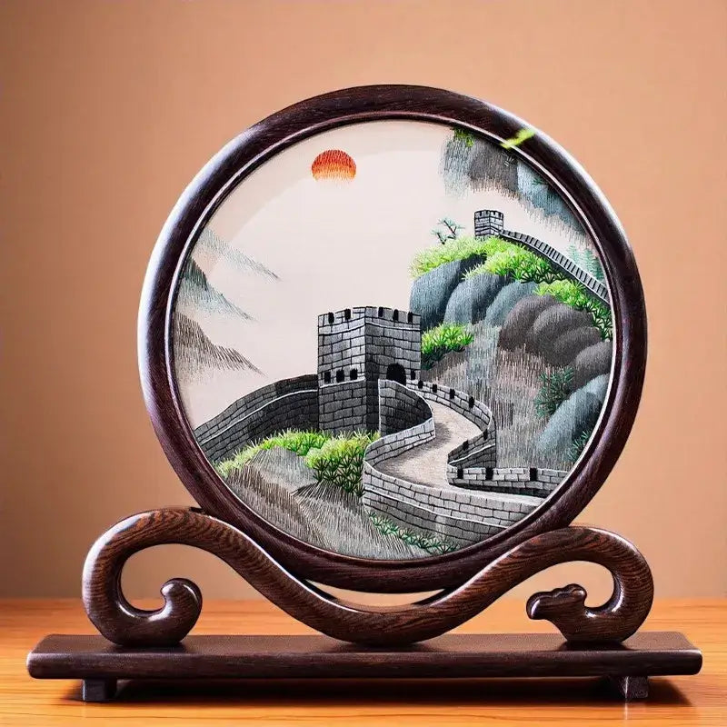 Decorative plate with a landscape design of a wall and trees on a wooden stand.