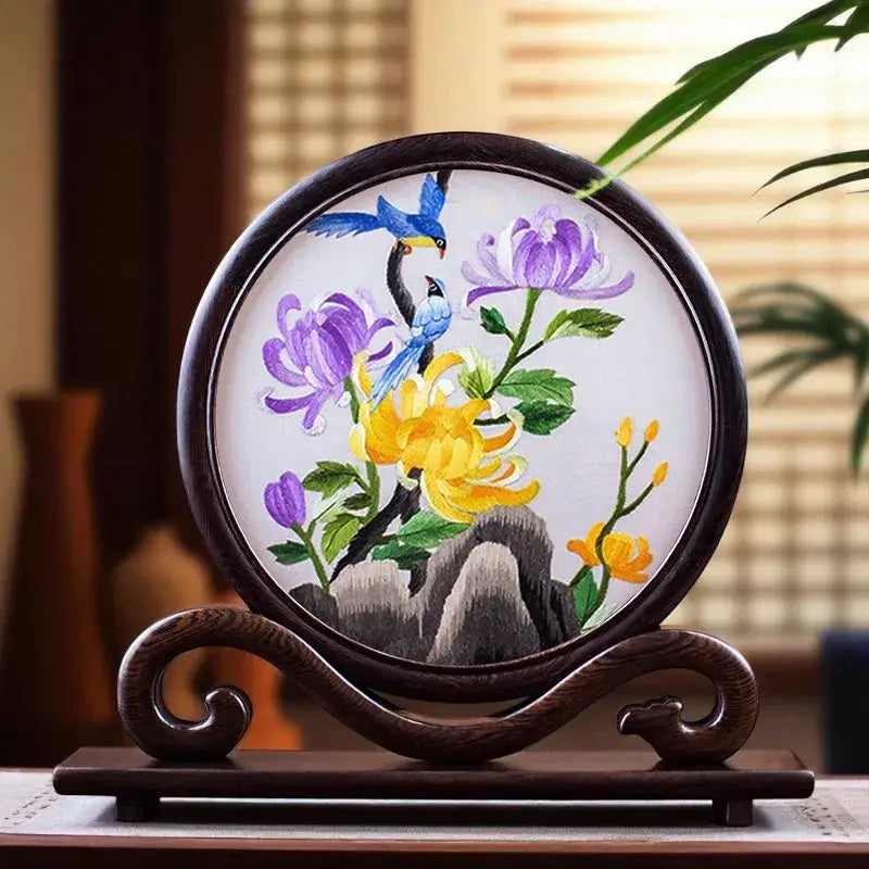 Decorative embroidery of flowers and birds on a wooden stand with a blurred background