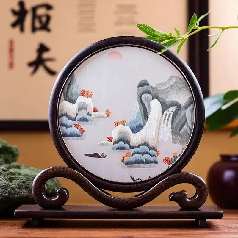 Decorative circular artwork with山水 (mountains and water) design on a wooden stand.