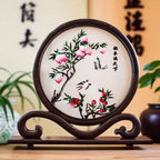 Decorative piece with floral design on a wooden stand against a blurred background