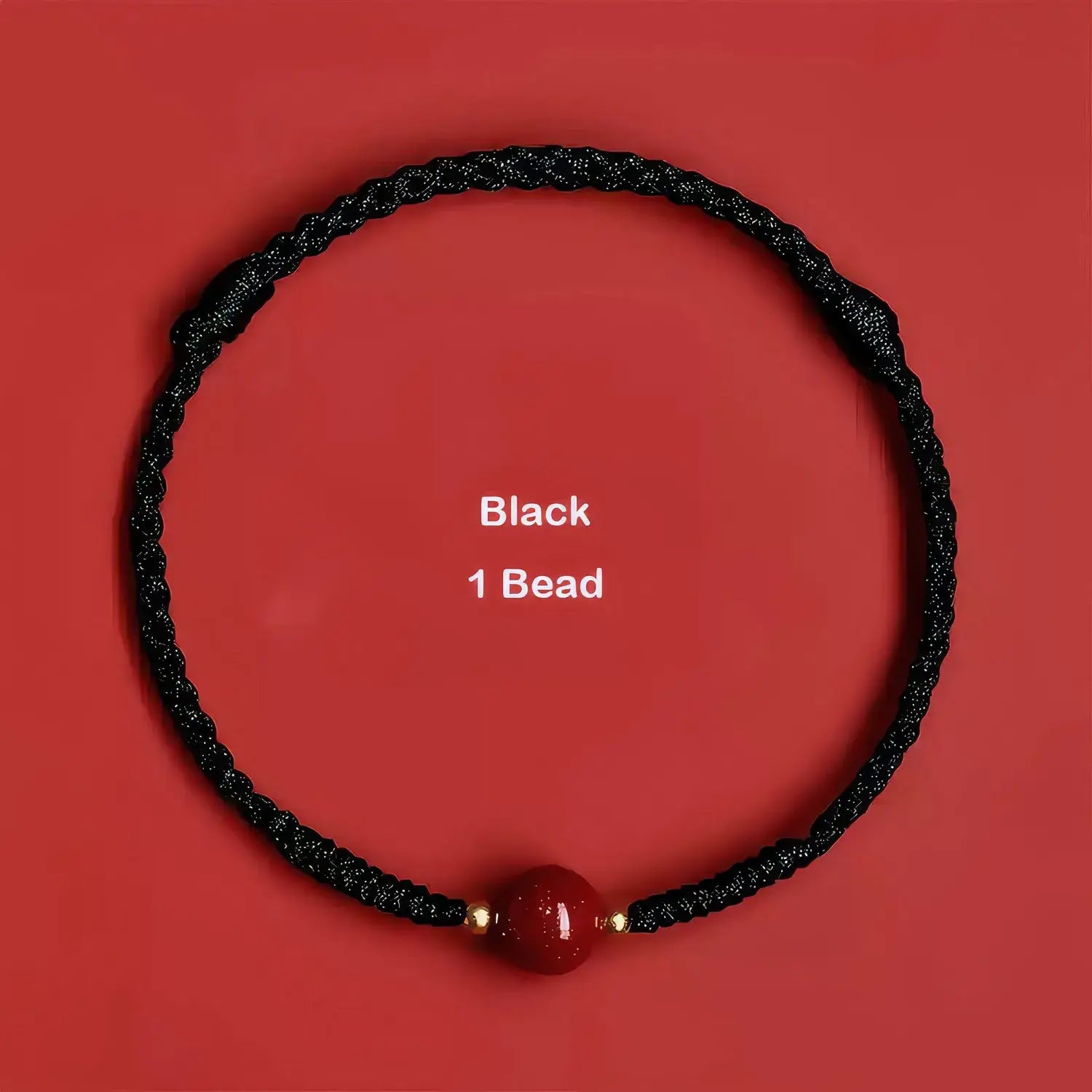 Black beaded necklace with a red bead on a red background