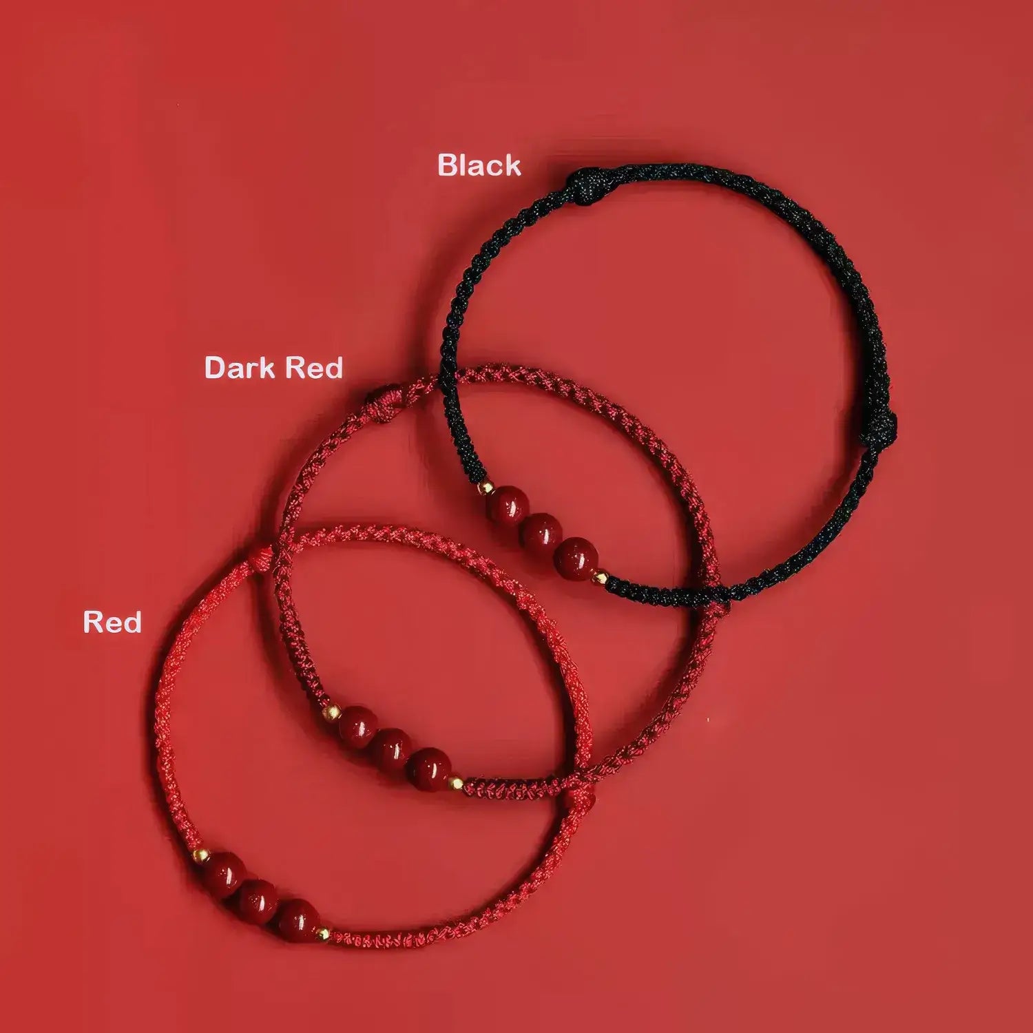 Three braided bracelets in red, dark red, and black on a red background.