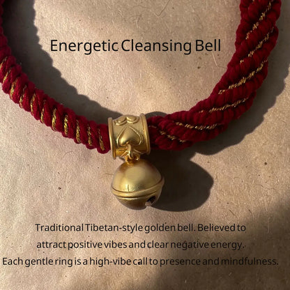 A red braided cord bell with a gold Tibetan-style belfry and hanging bell, shown on a textured beige surface with descriptive text overlays.