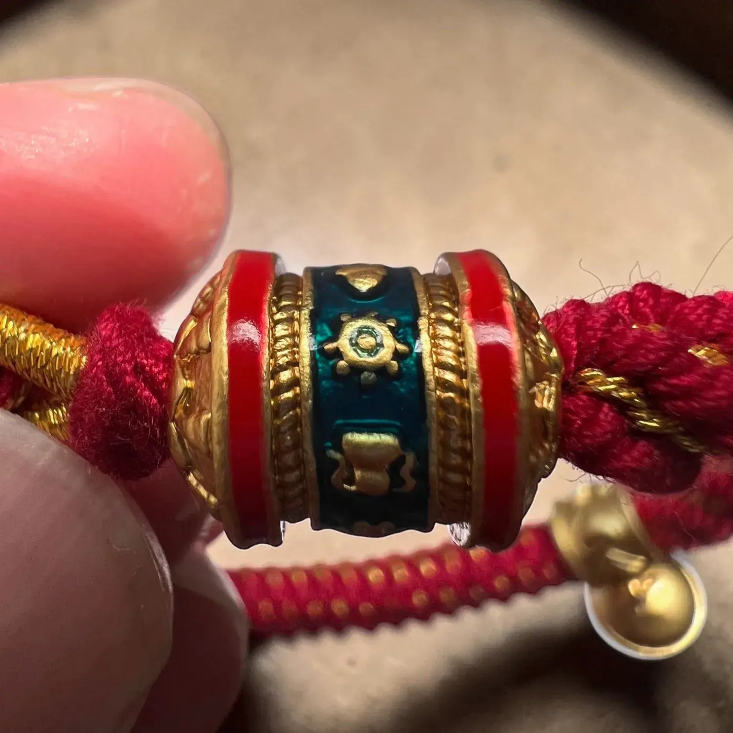 Close-up of a decorative bracelet with red, gold, and blue elements.