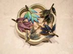 Colorful leaf-shaped brooches on a heart-shaped jewelry box