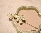 Floral hairpin with pearl accents on a heart-shaped green stand