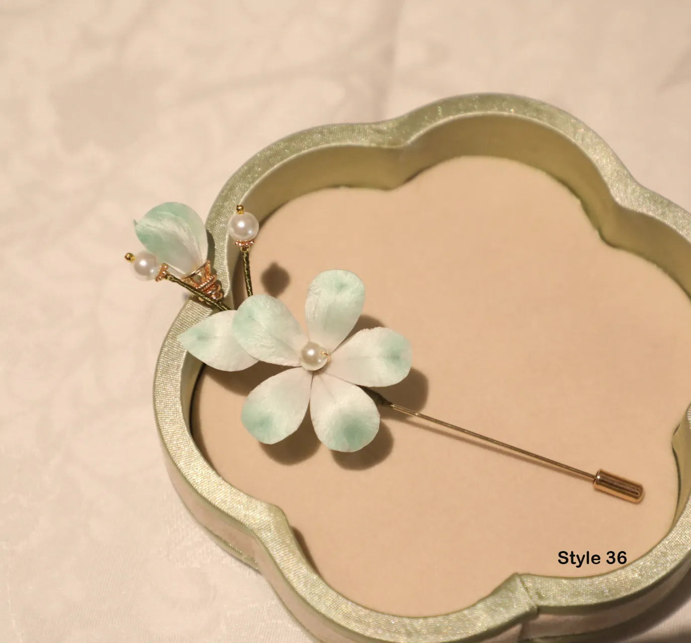 Floral hairpin with pearl accents on a decorative stand