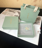 Green gift box with a message card on a textured surface