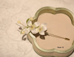 Floral hairpin with gold accents on a beige background