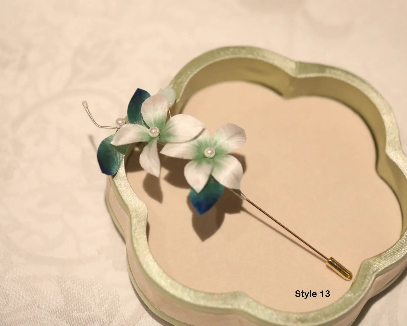 Floral brooch on a decorative box with 'Style 13' text