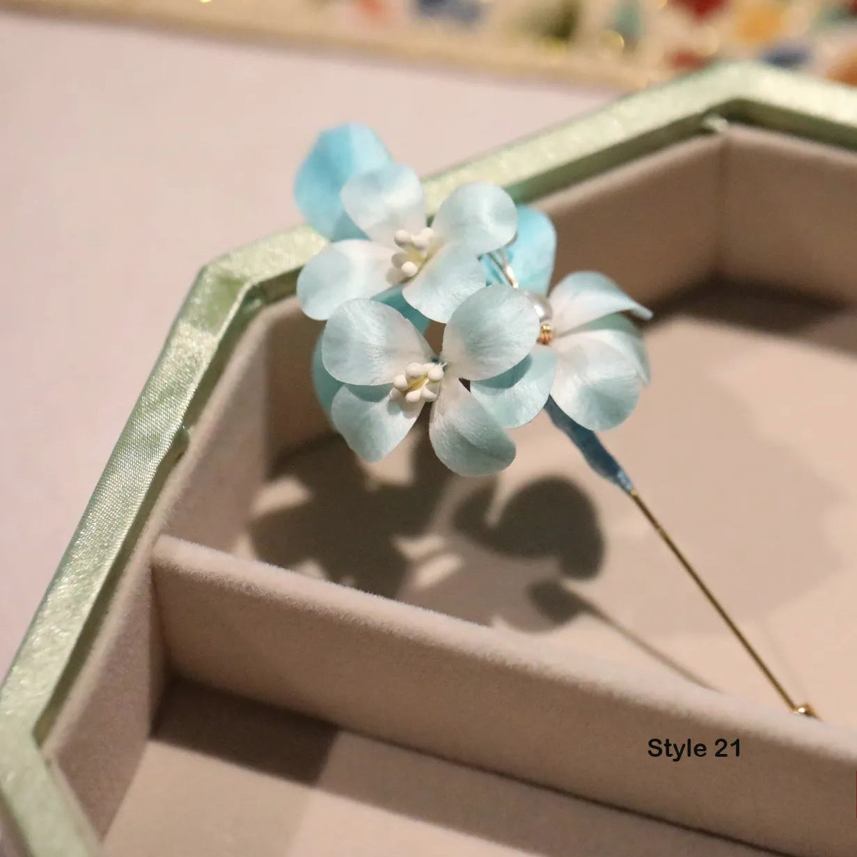 Light blue flower-shaped hair clip on a pink background