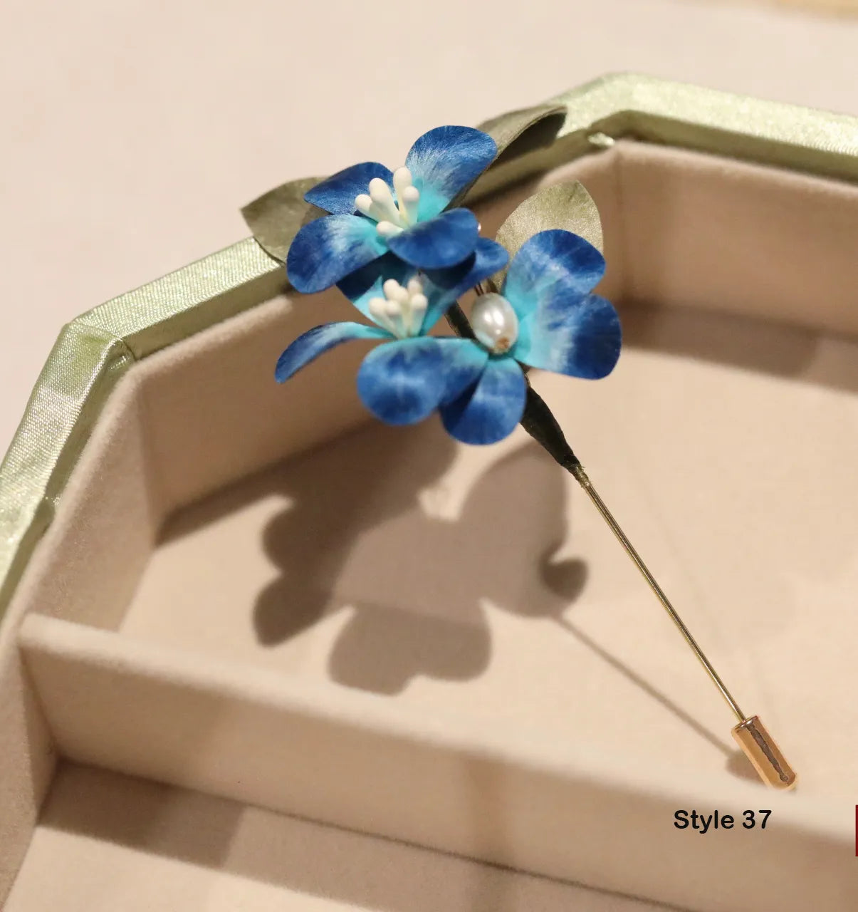 Blue floral hairpin with pearl center on a beige background