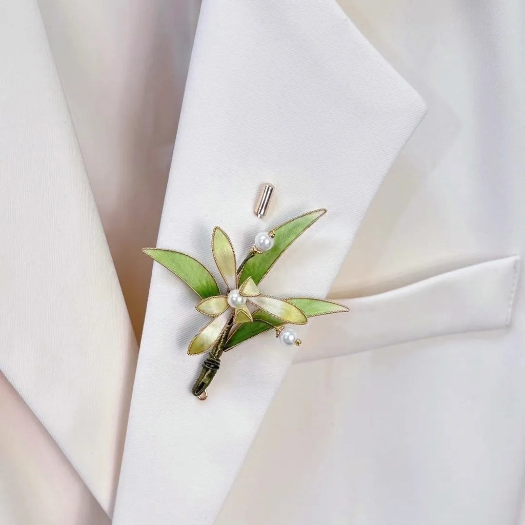 Green leaf brooch with pearls on a white jacket