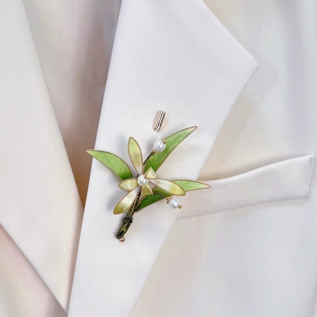 Green leaf brooch with pearls on a white jacket