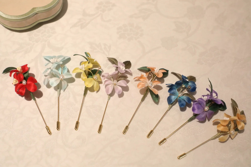 Colorful floral brooches on a textured beige surface