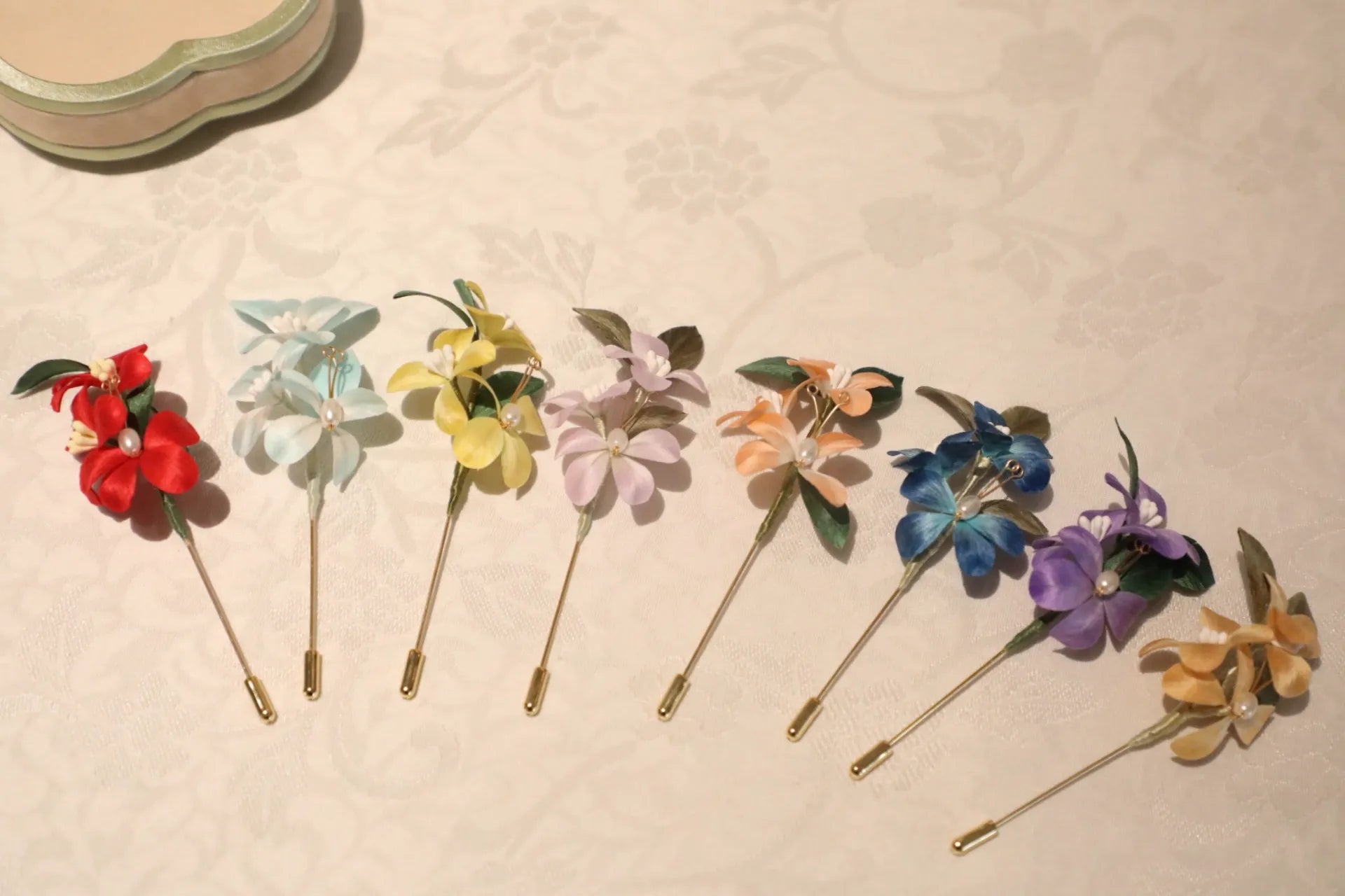 Colorful floral brooches on a textured beige surface