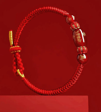 Red bracelet with gold accents and Chinese characters on a red background