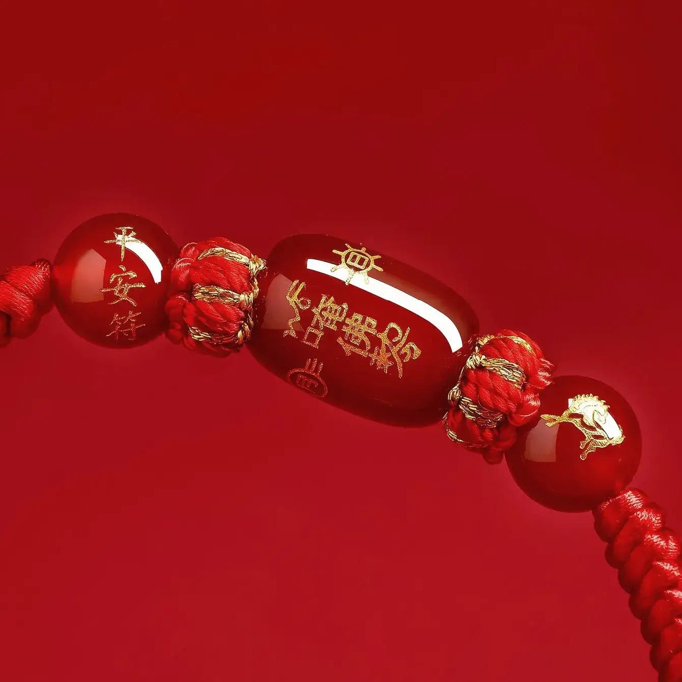 Red beaded bracelet with gold accents on a red background