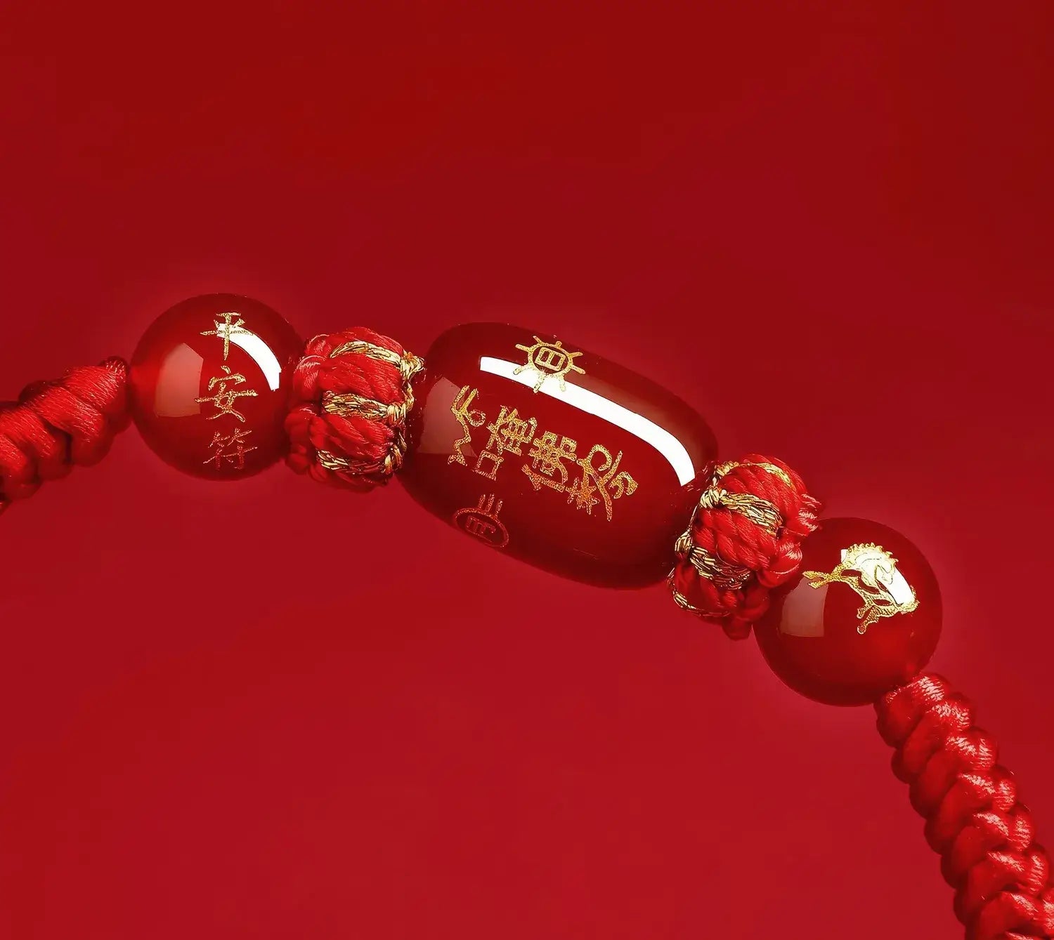 Red beaded bracelet with gold accents on a red background