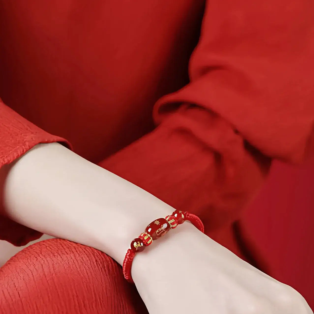 Red bracelet on a wrist with a red background