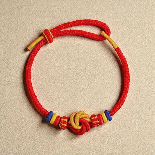 Red cord bracelet with colorful beads on a beige background