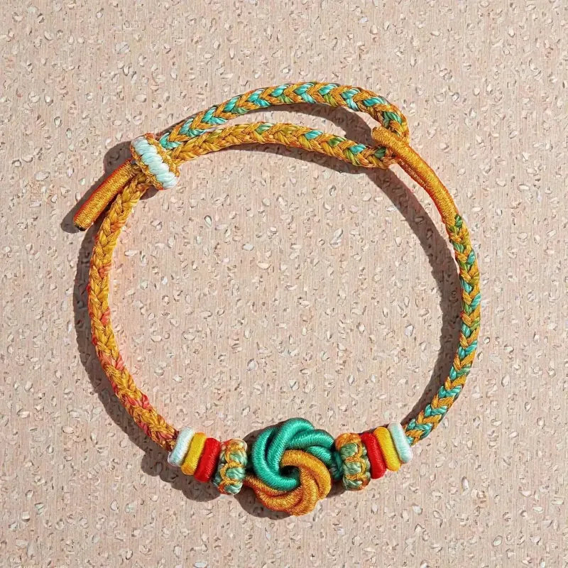 Colorful braided bracelet with beads on a textured beige surface