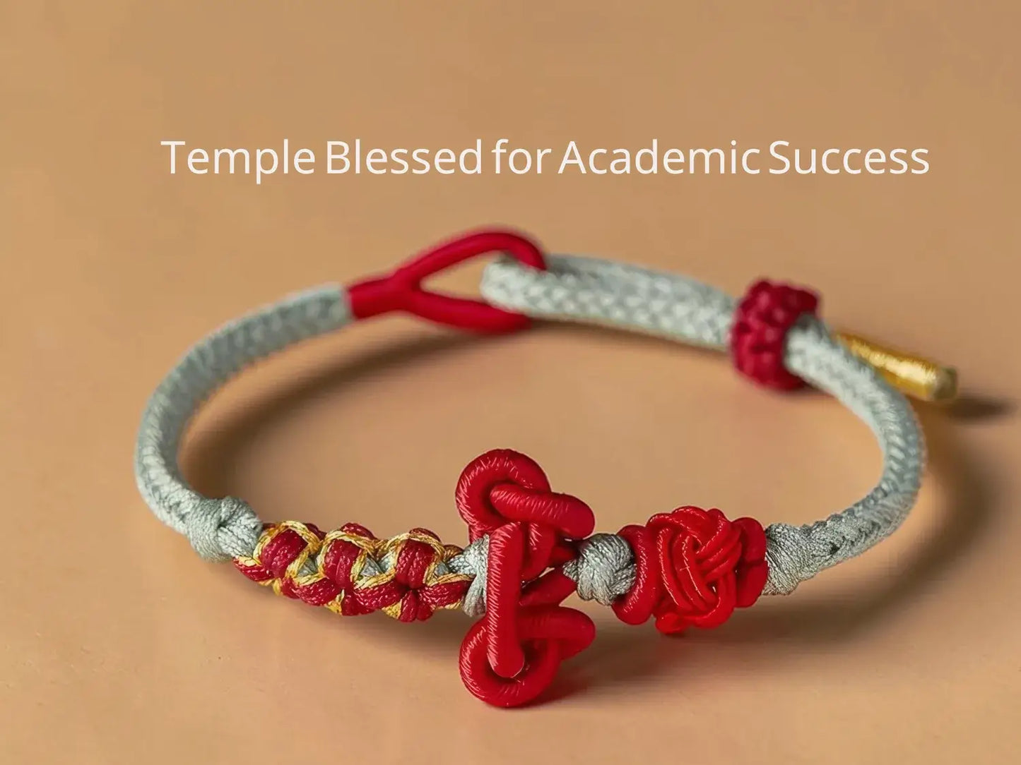 Bracelet with red and gold elements on a beige background, labeled 'Temple Blessed for Academic Success'.