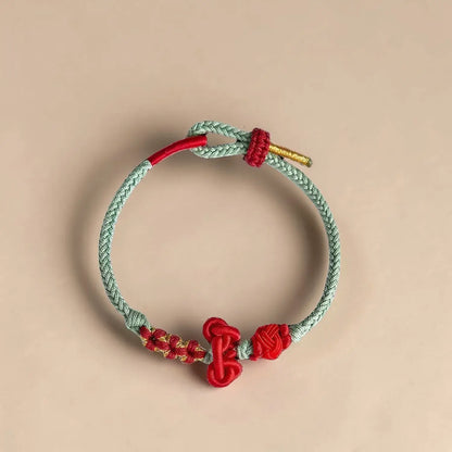 Bracelet with red and gold accents on a beige background
