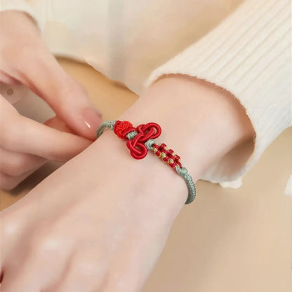 Red and silver bracelet on a wrist with a neutral background