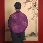 Person wearing a traditional embroidered garment with a scenic background