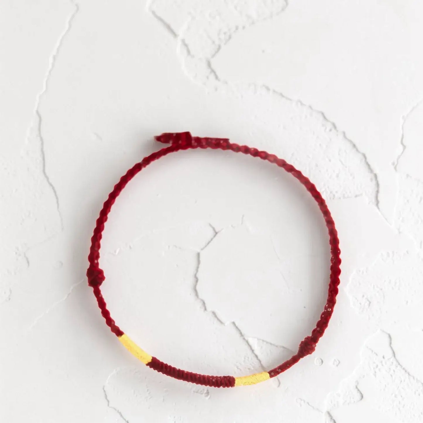 Red and yellow bracelet on a textured white surface
