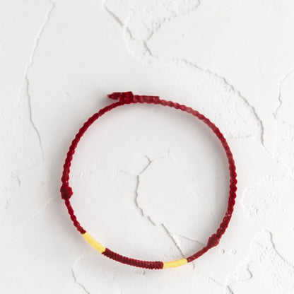 Red and yellow bracelet on a textured white surface