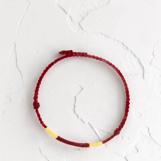 Red and yellow bracelet on a textured white surface