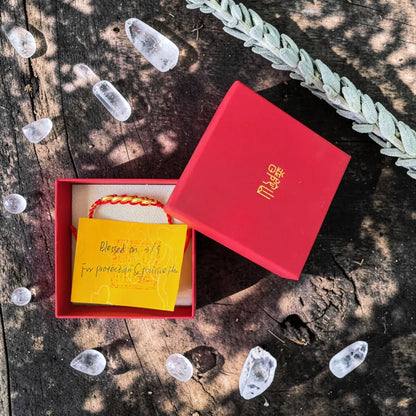 Red gift box with a yellow card on a rustic wooden surface with ice cubes.